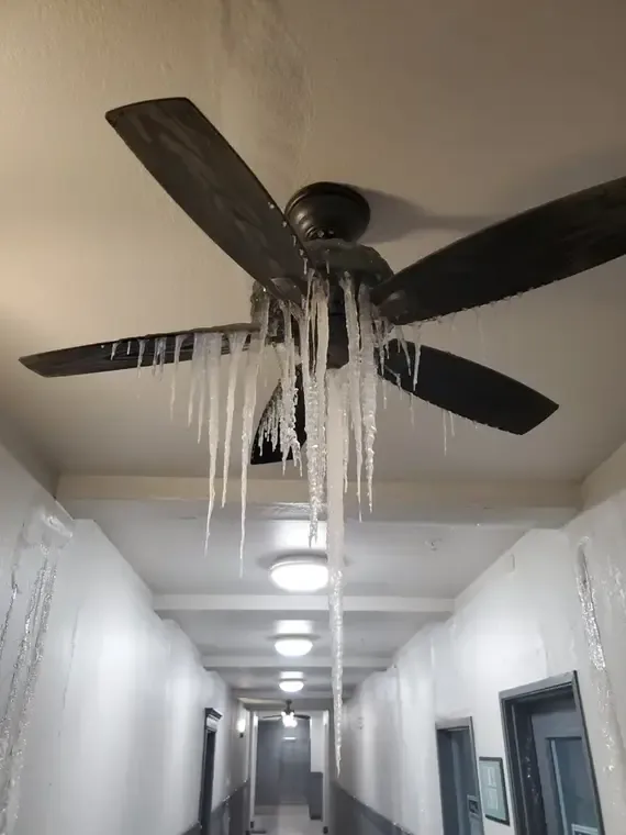 Icicles hanging from a ceiling fan in an apartment hallway after a pipe froze