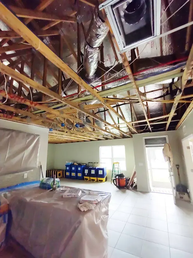 Opened ceiling with containment plastic and drying equipment during water damage restoration