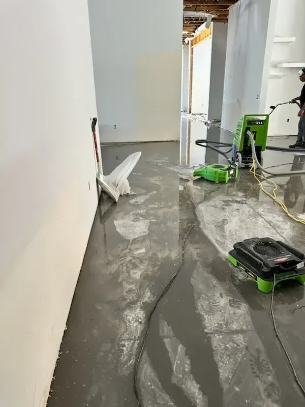 Water and cleaning equipment on a laundry room floor