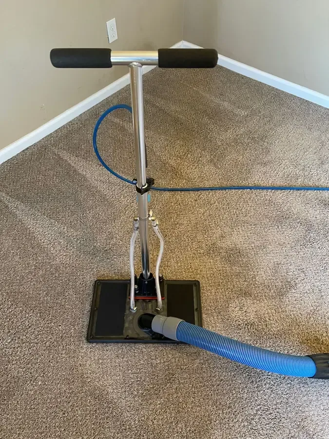 Flood extraction tool pulling water out of a wet carpet in a home