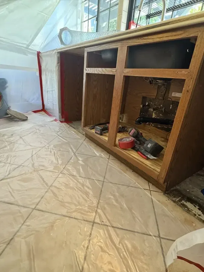 Cabinet base opened under containment for drying
