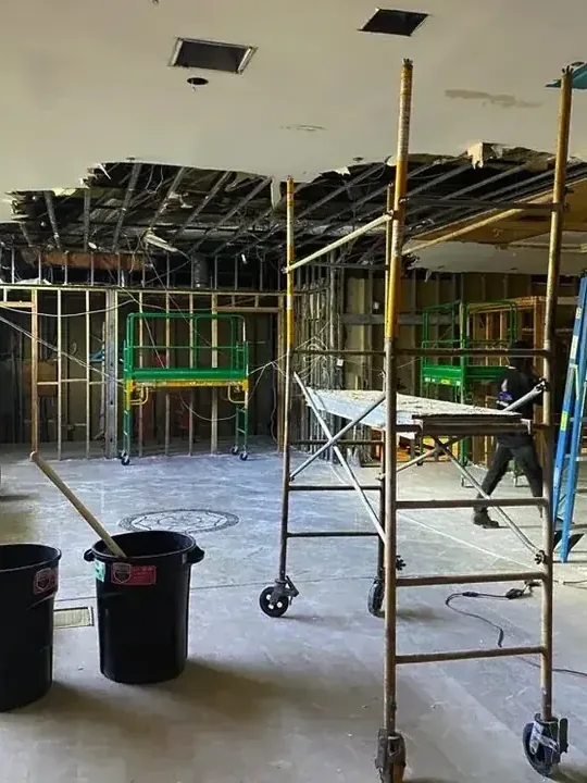 Ceiling and wall framing exposed in a room prepared for drying