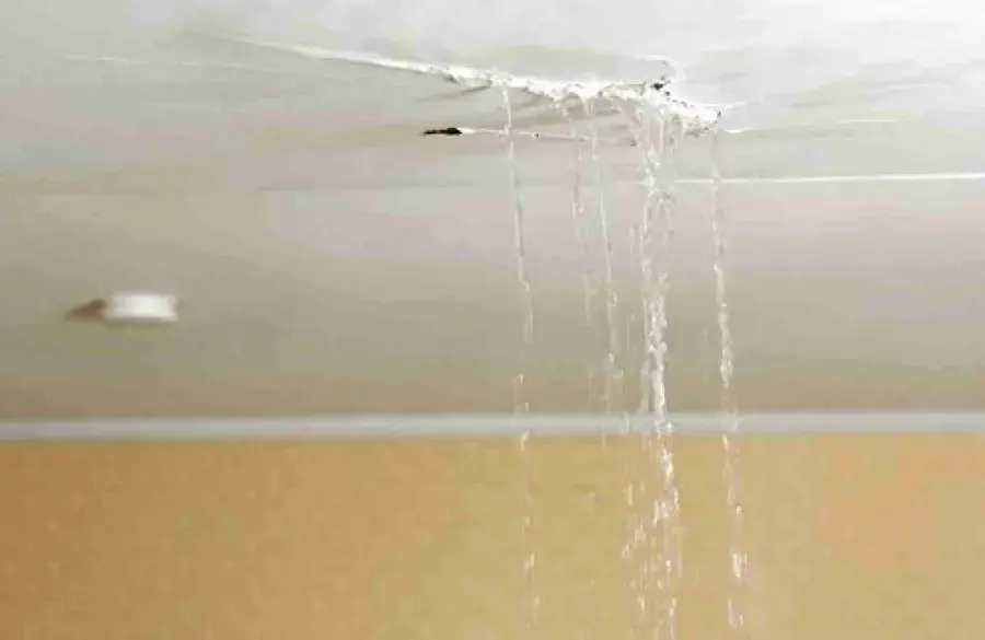 Water running from a cracked ceiling seam in a living room