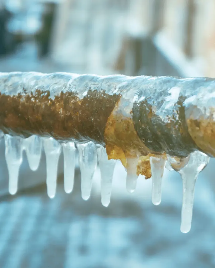 Frozen pipe water damage: an ice-coated pipe with icicles after a hard freeze